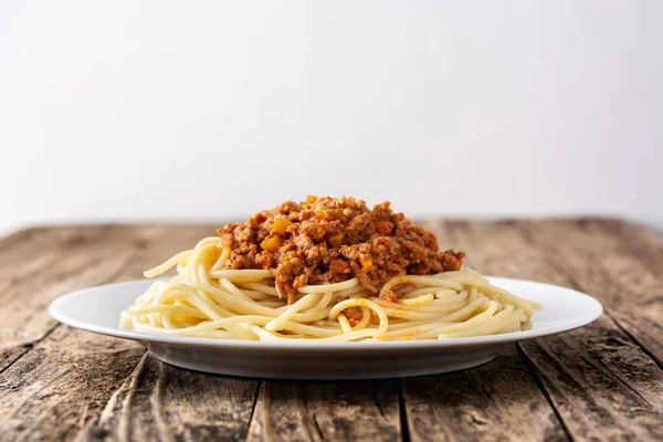 木製のテーブルの上にボロネーゼソースとスパゲッティ — ストック写真