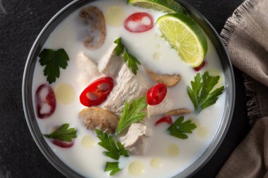 Geleneksel Tayland yemeği Tom Kha Gai, tahta masada kasede.