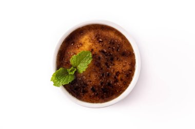 Beyaz arka planda ev yapımı creme brulee var. Üst görünüm
