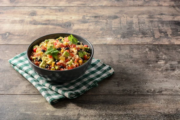 Tahta masadaki kase içinde Meksika salatası. Boşluğu kopyala