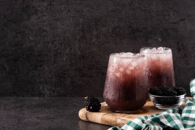 Taze böğürtlen kokteyli. Soğuk bardakta, siyah taşta.