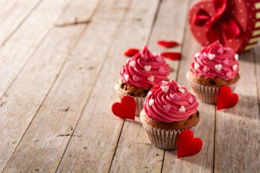 Şeker kalplerle süslenmiş kek ve ahşap masada Sevgililer Günü için aşk oku.