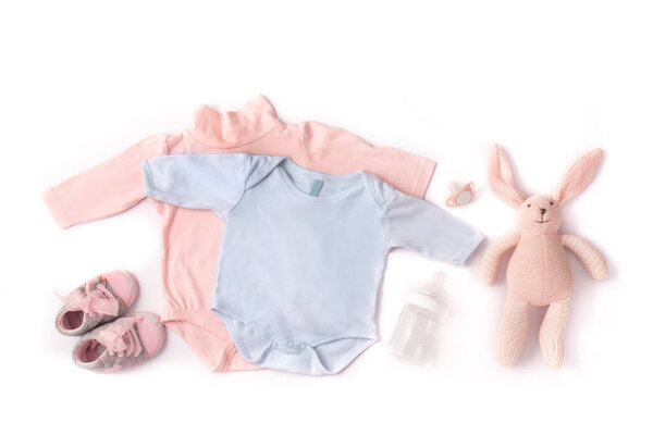 Детские коляски, обувь, бутылка для кормления, пацифист и игрушечный кролик изолированы на белом фоне