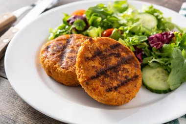 Tahta masada lezzetli, sağlıklı nohut burger ve salata.