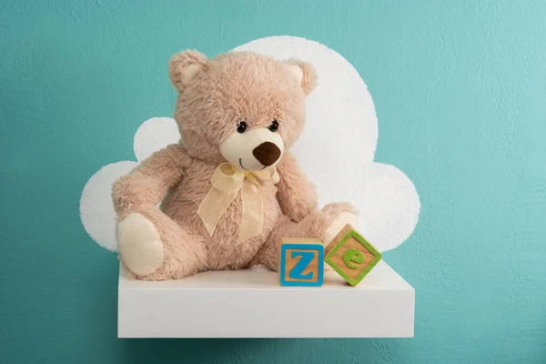 Teddybär Auf Weißem Regal Und Türkisfarbener Wand — Stockfoto