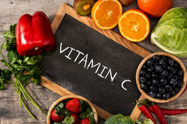 High in vitamin C food and blackboard on wooden table.