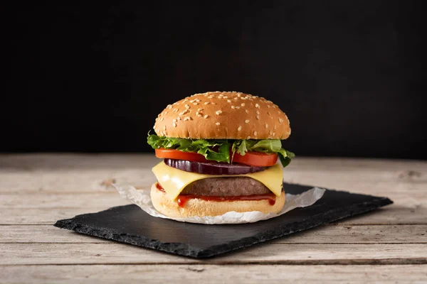 Cheeseburger Wołowiną Pomidorami Sałatą Cebulą Drewnianym Stole — Zdjęcie stockowe
