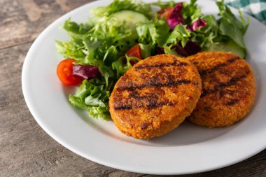 Tahta masada lezzetli, sağlıklı nohut burger ve salata..