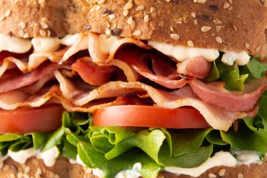 Beyaz arkaplanda BLT sandviç ve patates kızartması var.