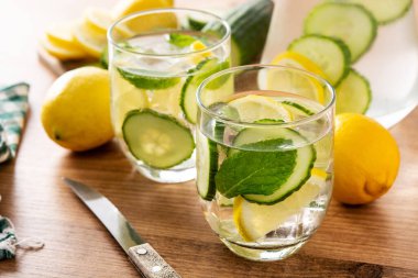 Ahşap masada salatalık, limon ve nane ile sulu su