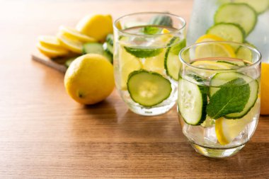 Ahşap masada salatalık, limon ve nane ile sulu su