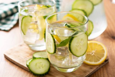 Ahşap masada salatalık ve limon ile sulu su