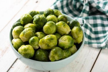 Beyaz ahşap masadaki kasede brussel lahanası.