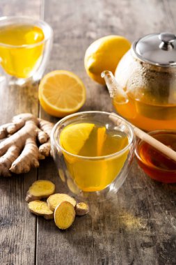 Limonlu zencefil çayı ve ahşap masada kristal bardakta bal.