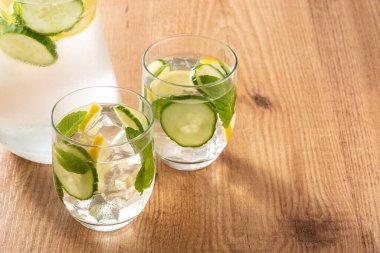 Ahşap masada salatalık ve limon ile sulu su. Boşluğu kopyala