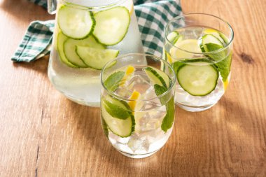 Ahşap masada salatalık ve limon ile sulu su