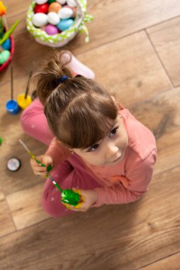 Evde paskalya yumurtası boyayan bir bebek..