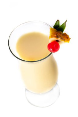 Beyaz arka planda izole edilmiş bir parça ananas ve kiraz ile süslenmiş Pina colada kokteyli.