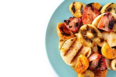 Beyaz arka planda izole edilmiş mavi bir tabakta ızgara meyve. Üst Manzara. Boşluğu kopyala