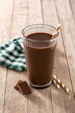 Çikolatalı milkshake. Tahta masada cam içinde.