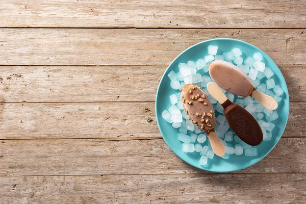 Paletas Chocolate Hielo Picado Sobre Plato Azul Sobre Mesa Madera —  Fotos de Stock