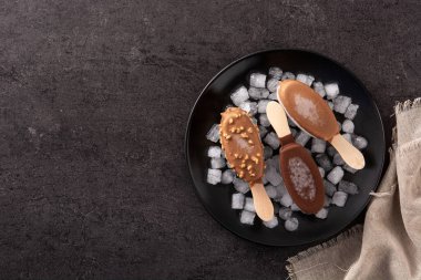 Çikolatalı dondurma ve siyah arka planda ezilmiş buz. Üst Manzara. Boşluğu kopyala