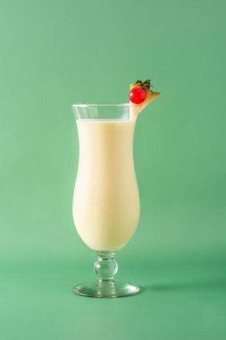 Yeşil arka planda cam kaplı Pina colada kokteyli