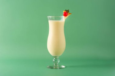 Yeşil arka planda cam kaplı Pina colada kokteyli