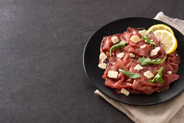 Siyah arkaplanda mermer sığır carpaccio. Boşluğu kopyala