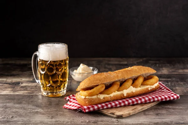 カラマリリングのサンドイッチと木製のテーブルの上のビール — ストック写真