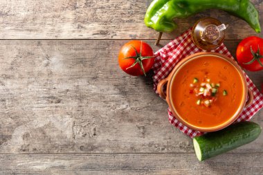 Güveç kabında gazpacho çorbası ve ahşap masada malzeme. Üst Manzara. Boşluğu kopyala