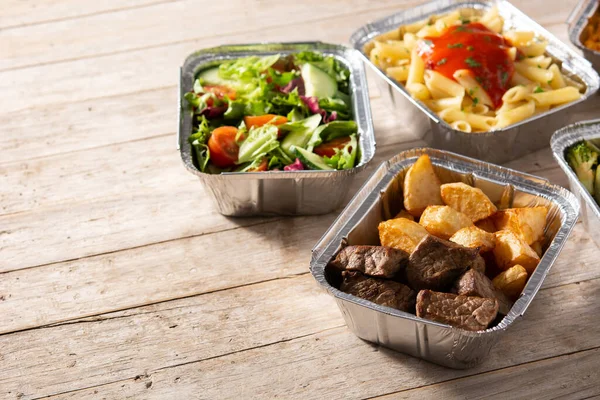 把健康的食物放在木制桌子上的铝箔盒里带走 复制空间 — 图库照片