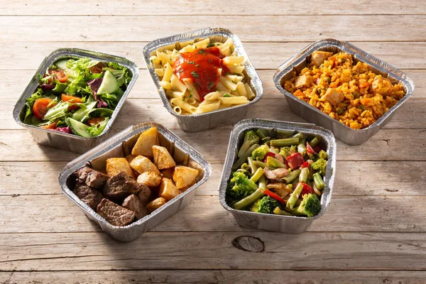 把健康的食物放在木制桌子上的铝箔盒里带走 — 图库照片