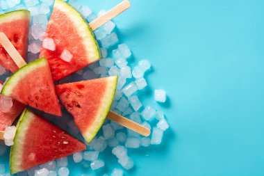 Karpuz dilimleri buzlu dondurmalar ve mavi arka planda buz. Boşluğu kopyala