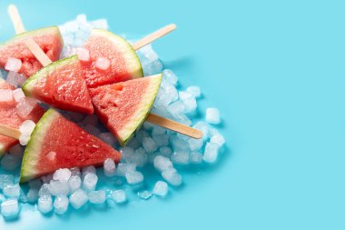 Karpuz dilimleri buzlu dondurmalar ve mavi arka planda buz. Boşluğu kopyala