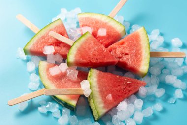 Karpuz dilimleri buzlu dondurmalar ve mavi zemin üzerinde buz