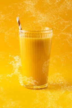 Lezzetli vanilyalı milkshake Sarı arka planda cam sıçradı