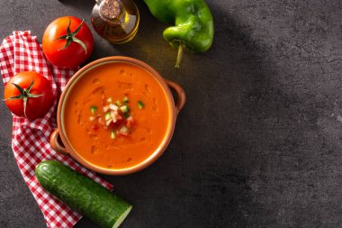 Çömlek kabında gazpacho çorbası ve siyah taşın üzerinde malzemeler. Üst Manzara. Boşluğu kopyala