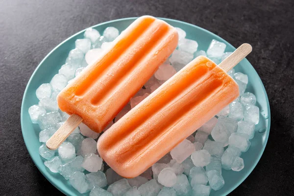 Orange Popsicles Blue Plate Black Background — Stock Photo, Image