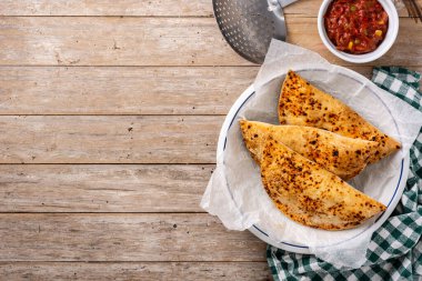 Geleneksel Şili börekleri ahşap masada. Üst Manzara. Boşluğu kopyala