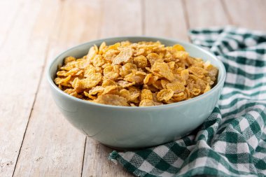 Tahta masada mavi bir kasede mısır gevreği.