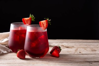 Kırsal ahşap masa ve siyah arka planda camlı çilek kokteyli. Boşluğu kopyala