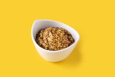 Beyaz kasede hardal sosu ve sarı arka plan