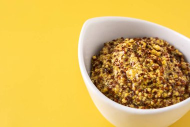 Beyaz kasede hardal sosu ve sarı arka plan. Boşluğu kopyala