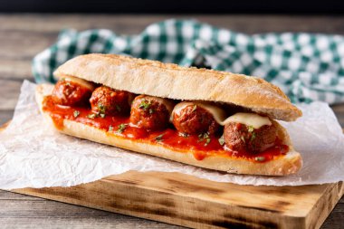 Köfteli sandviç ahşap masada.