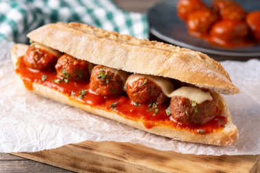 Köfteli sandviç ahşap masada.