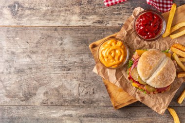 Ahşap masada domuz pastırmalı sığır burger. Üst Manzara. Boşluğu kopyala