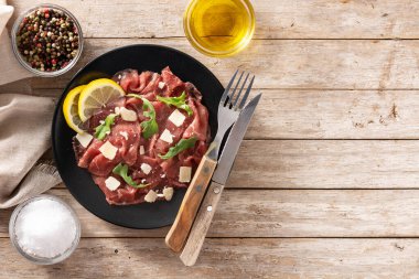 Siyah tabakta mermer sığır carpaccio ve kırsal ahşap masa. Üst Manzara. Boşluğu kopyala