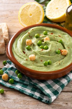 Yeşil bezelye humusu ve ahşap masada pide ekmeği