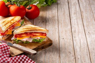 Domatesli sandviç, marul, jambon ve peynirli ahşap masa. Boşluğu kopyala